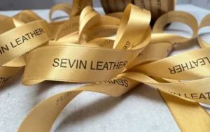 روبان طلایی 2/5 سانتی متری ساتن با چاپ مشکی SEVIN LEATHER متراژ 1000 متری