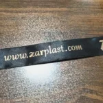 روبان 1/5 سانتی متری مشکی با چاپ طلایی ZARPLAST تیراژ 1000 متری